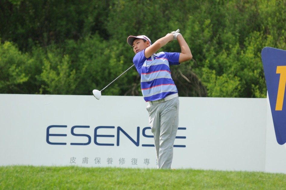 少年球手金博完成击球后，动作潇洒地随挥收杆，身姿挺拔而自信