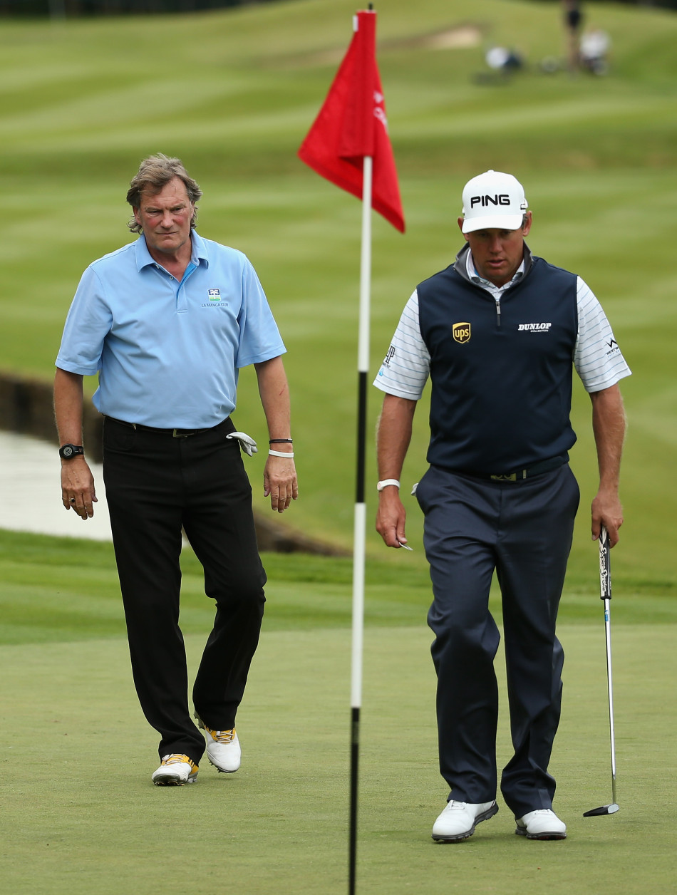 格伦·霍德尔俯身在一片长草区中仔细寻找小球，神情专注，展现了高尔夫运动中所需的耐心与细致。