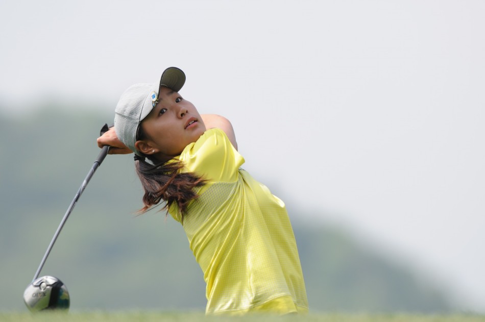 女球手凝神静气，优雅收杆，身姿如松，裙摆随风轻扬