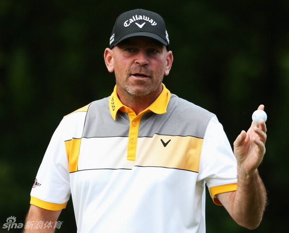 托马斯·比约恩在温特沃斯西球场的果岭边凝神观察推杆线路，神情专注，展现出大赛领先者的沉着与自信。