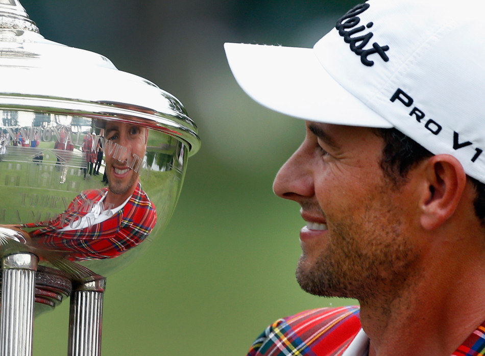 亚当·斯科特深情凝视冠军奖杯，眼中闪烁着梦想成真的光芒。