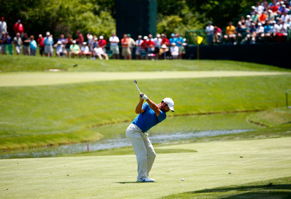 高尔夫球手在沙坑中奋力一击,沙砾飞扬,小球带着希望飞向果岭目标。