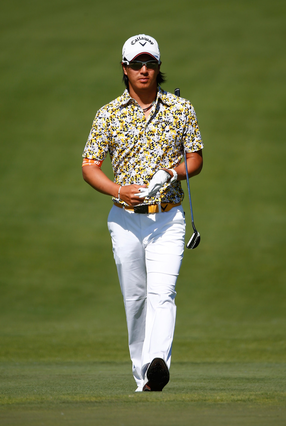 亚当·斯科特在风景如画的球场上漫步，脸上带着标志性的和煦微笑，享受着比赛与自然交融的惬意时刻。