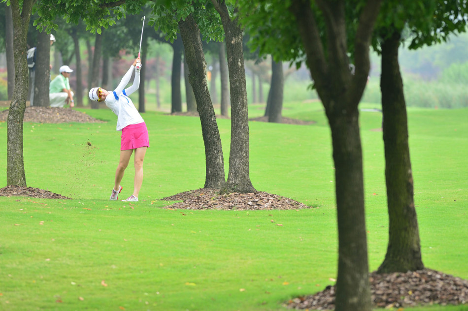 潘艳红俯身果岭专注研判推杆线路