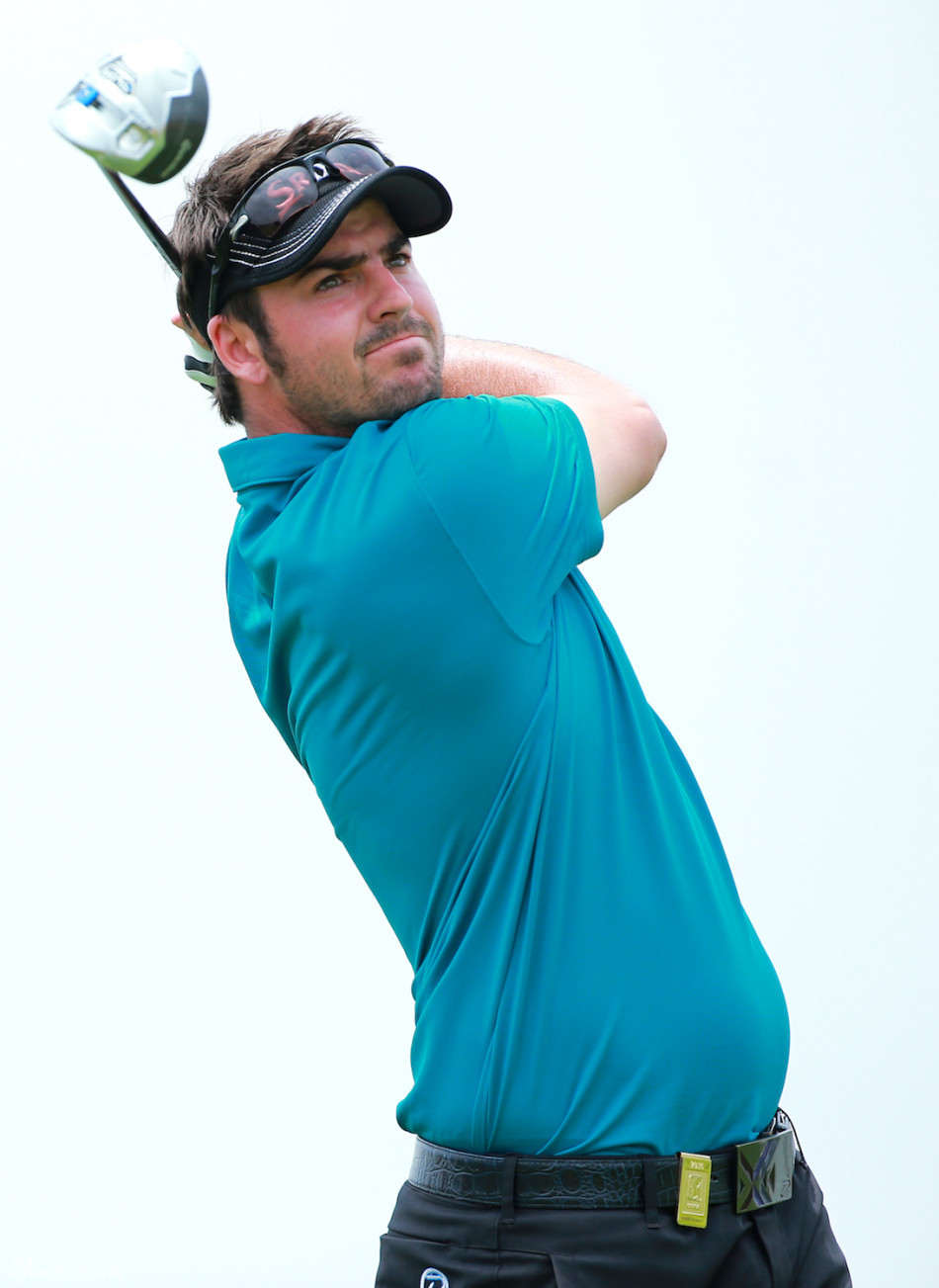 张新军站在长草区中，眉头微蹙，全神贯注地审视前方果岭的球路，谋划着下一杆的脱困策略。