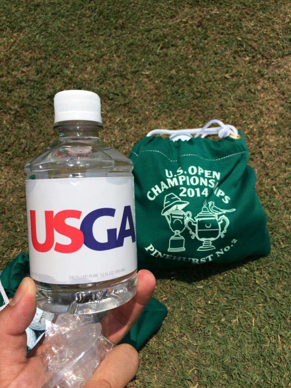 梁文冲在松针球场优美的自然环境中完成潇洒的挥杆动作，姿态流畅而充满力量。