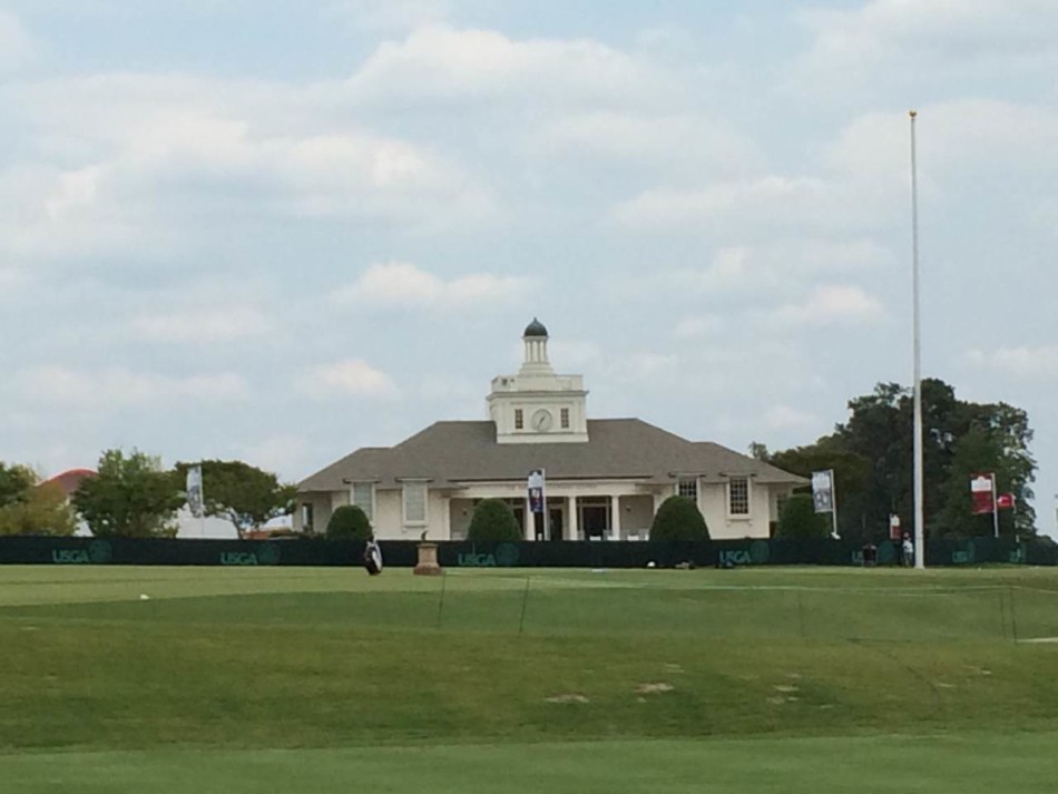 梁文冲与球童在球道上认真讨论下一杆的策略，展现团队合作与专业态度。