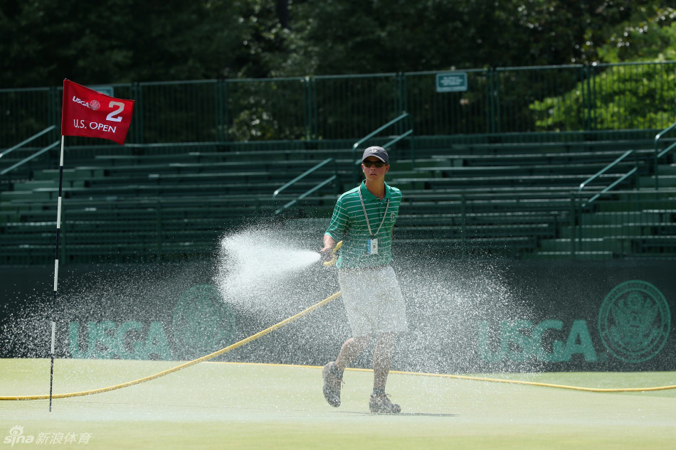 晨曦中的果岭守护者：养护人员正在精心修整起伏如波浪的果岭表面，为大赛做最后准备