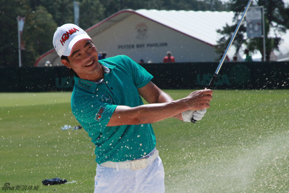 梁文冲与日本球童Koji在球场边交流，神情认真而融洽