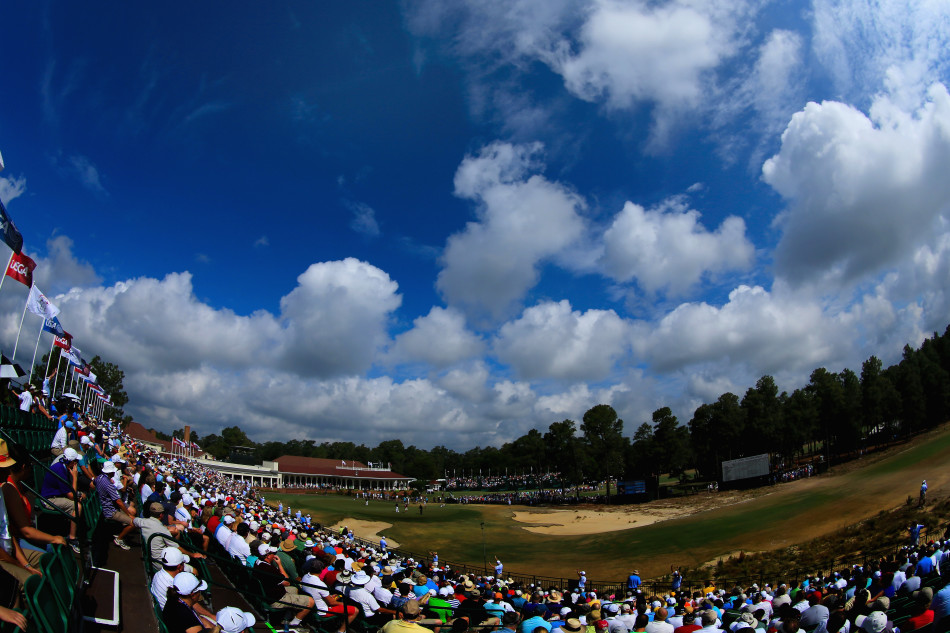 一位高尔夫球员在果岭边优雅推杆，他的动作稳定而专注，现场观众在背景中模糊成一片安静的色块，凸显了比赛关键时刻的凝重与优雅。