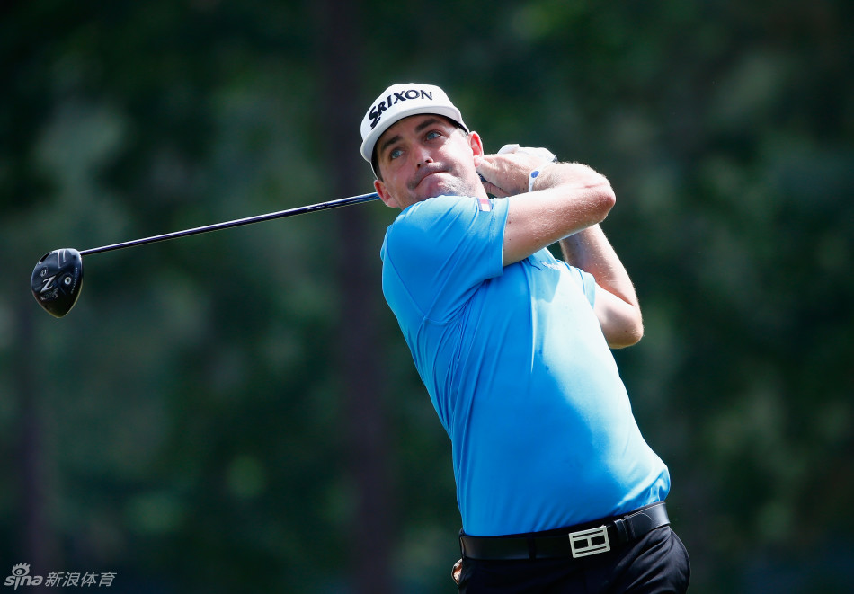 在观众的环绕下，一位球员完成了一记漂亮的沙坑救球，沙粒飞扬的瞬间被定格，球童在一旁密切关注球的落点。