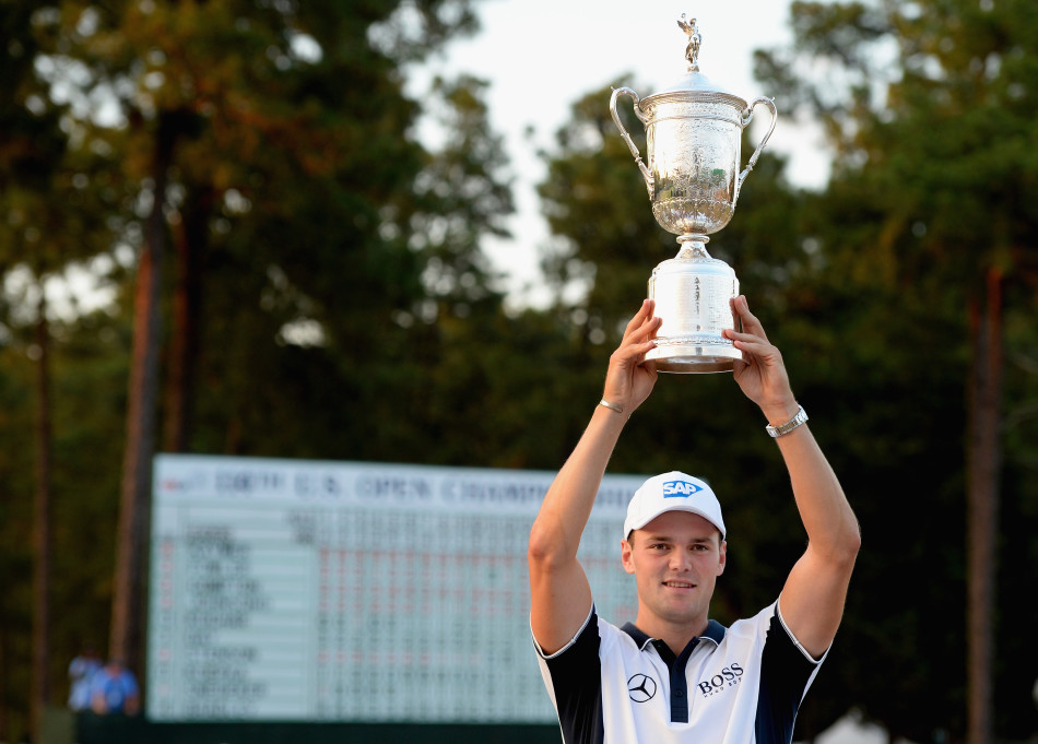 凯梅尔面带标志性的腼腆笑容，双手稳稳地捧着冠军奖杯，展现出胜利者的谦逊与优雅，尽显冠军风范。