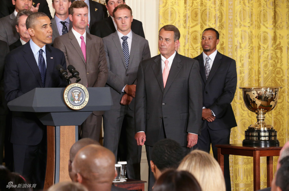 白宫东厅内，奥巴马总统站在讲台前发表幽默讲话，身后两侧分别站着副总统拜登和众议长博纳，下方坐满了身着正装的高尔夫球星们