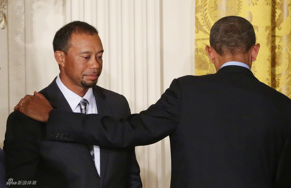 伍兹与扎克·约翰逊在台下观众席中并肩而坐，神情专注地聆听台上发言