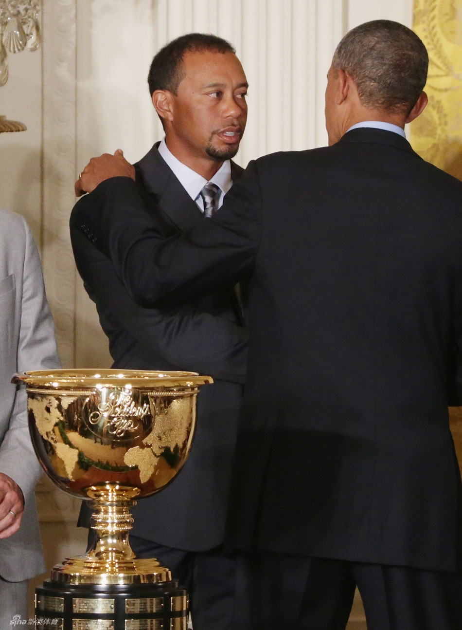 伍兹与扎克·约翰逊两人站在白宫华丽的走廊或厅堂内，似乎在等待或进行非正式交流，背景是古典的廊柱