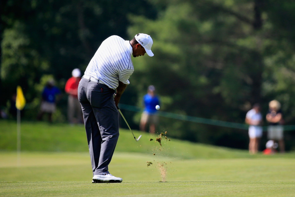 泰格·伍兹全力挥杆木杆瞬间，身体如旋风般扭转，杆头划破空气，充满爆发力