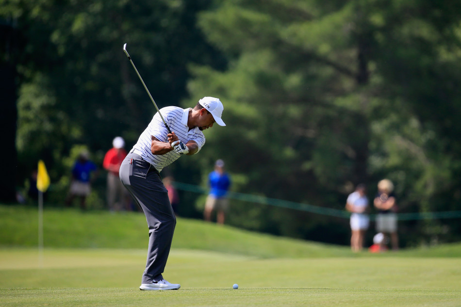 伍兹完成优雅的铁杆击球，身体跟随杆头自然舒展，目光追随着球飞向果岭