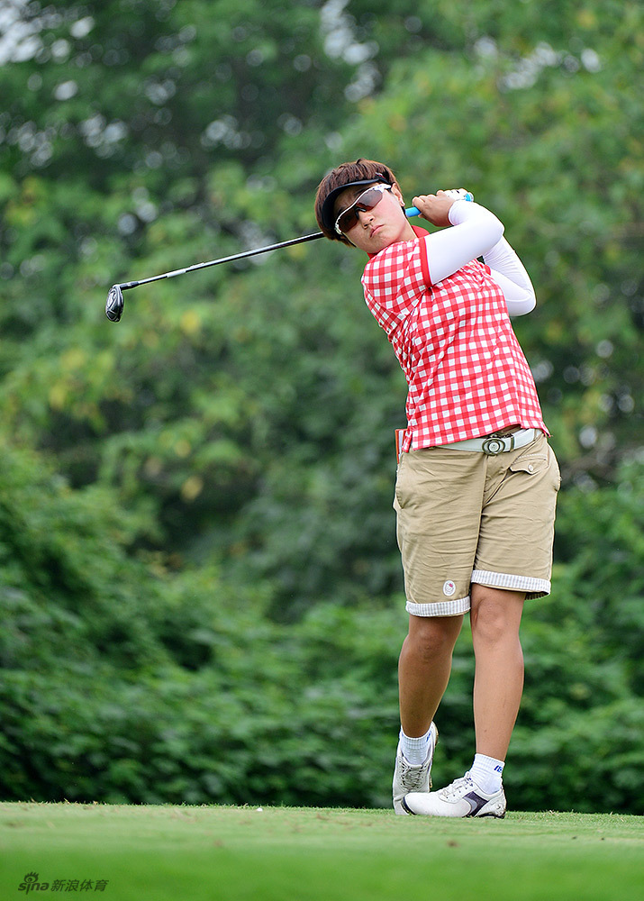 李丹在球道上稳健挥杆，动作一气呵成，专注的眼神追寻着小白球的飞行轨迹。