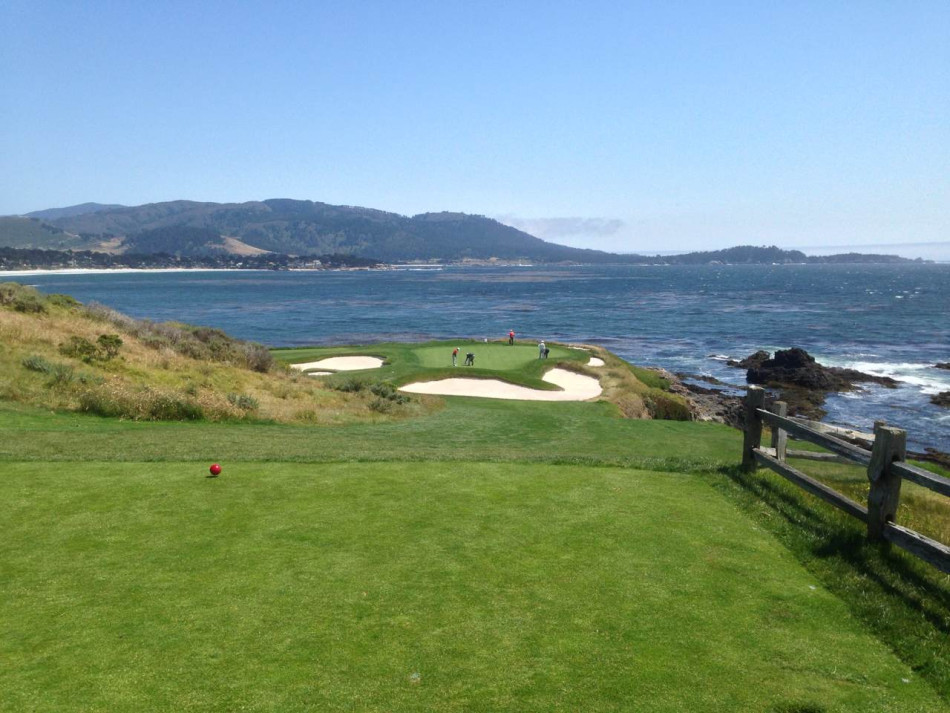 身着红色上衣的球手在发球台优雅挥杆，动作流畅，与背景中简约的会所建筑和天空构成一幅动静相宜的运动画面