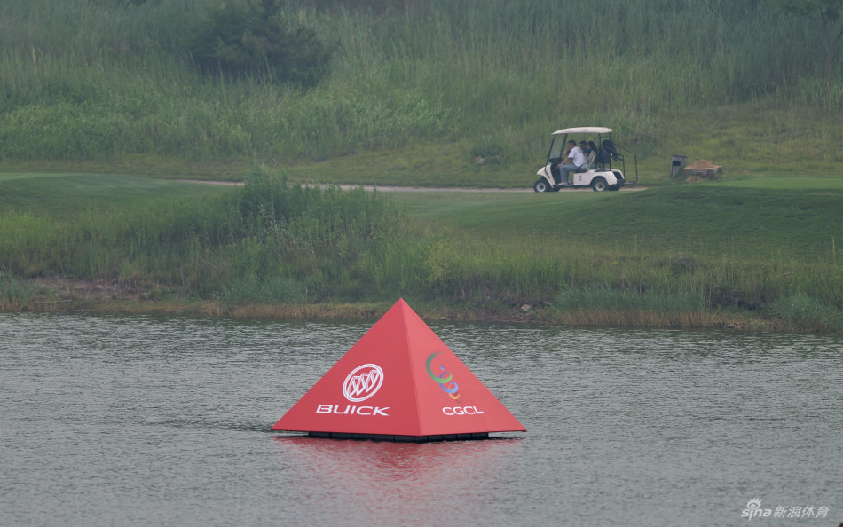 风景如画的桃源江景精英场某洞，两名试场球员正在评估攻果岭的最佳线路，远处江景与球场浑然一体。