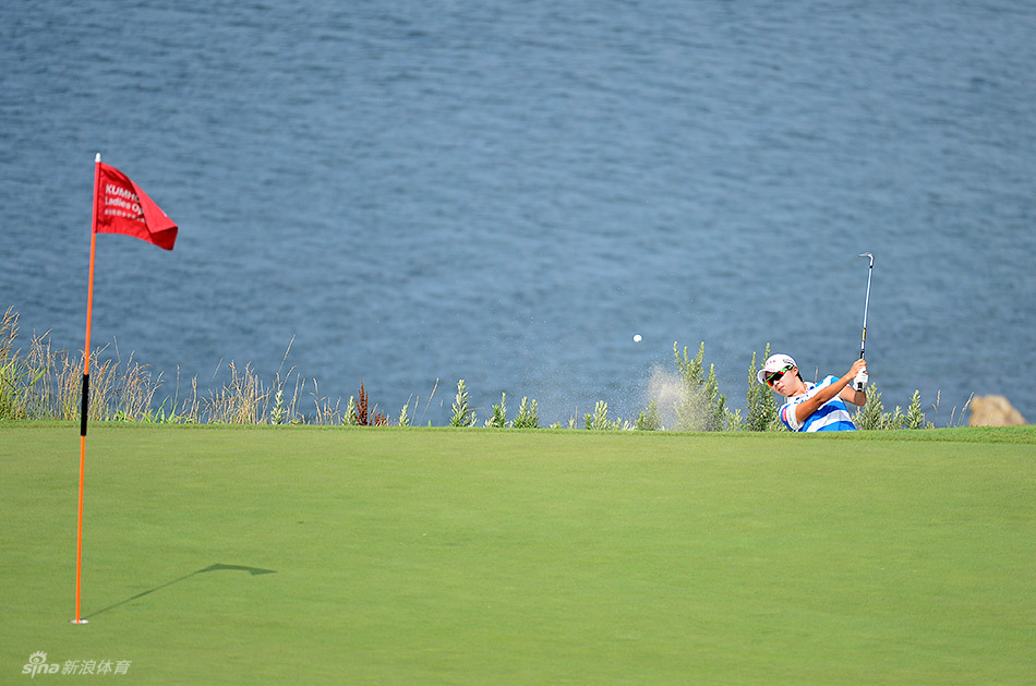 金孝周在沙坑中完成一次漂亮的救球，沙粒飞扬，她身体姿态平衡，目光紧随小球轨迹。