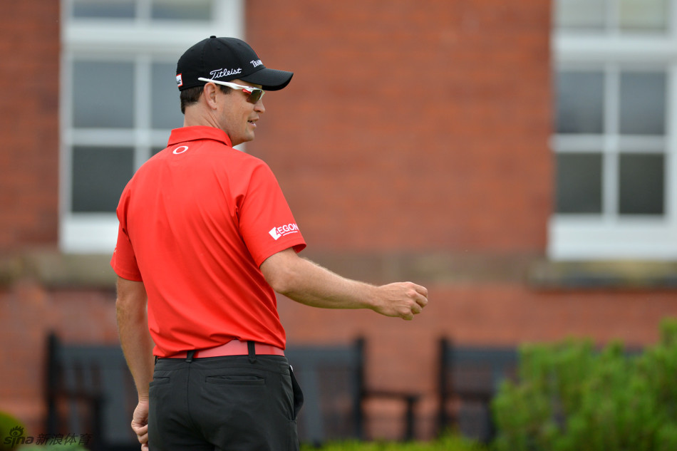 吴阿顺在比赛间隙与球童沟通战术，他手指果岭方向，两人正认真分析下一杆的进攻策略。