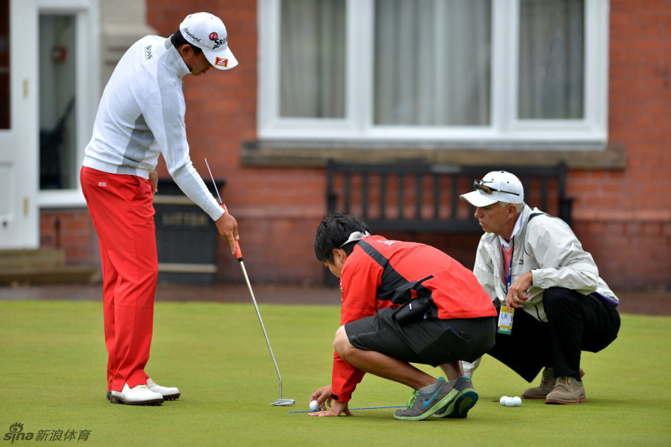 吴阿顺在赛前认真检查球杆握把的状况，神情专注，确保装备处于最佳状态。