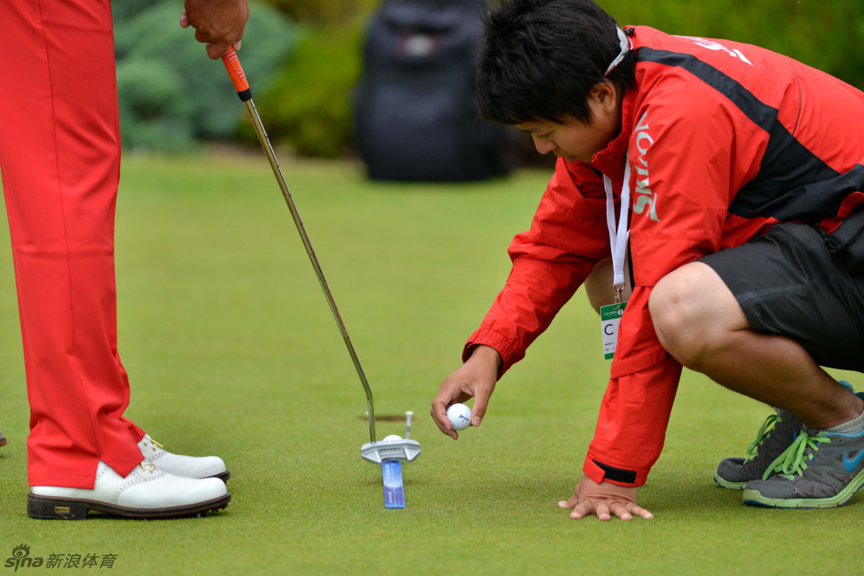吴阿顺与身穿红衣的美国名将Z.约翰逊在球道上并肩行走，两人面带微笑，正在进行轻松的赛前交流。