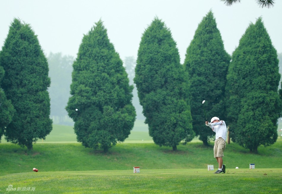 程瀚宇在果岭上仔细观察线路，正准备进行一次关键的推杆，神情专注