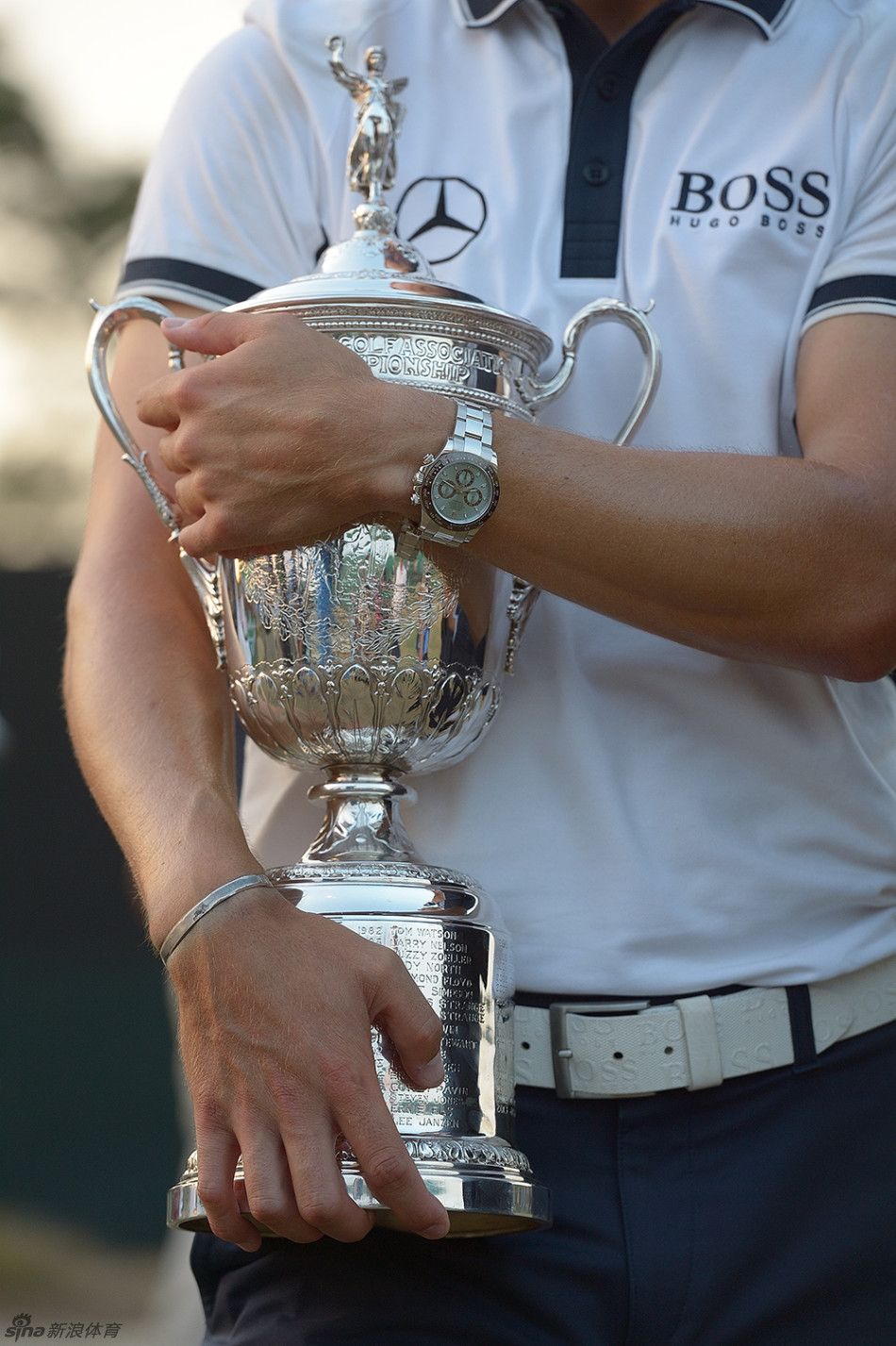 冠军荣耀时刻，马丁·凯梅尔面带灿烂笑容，双手高高举起象征最高荣誉的美国公开赛大奖杯。