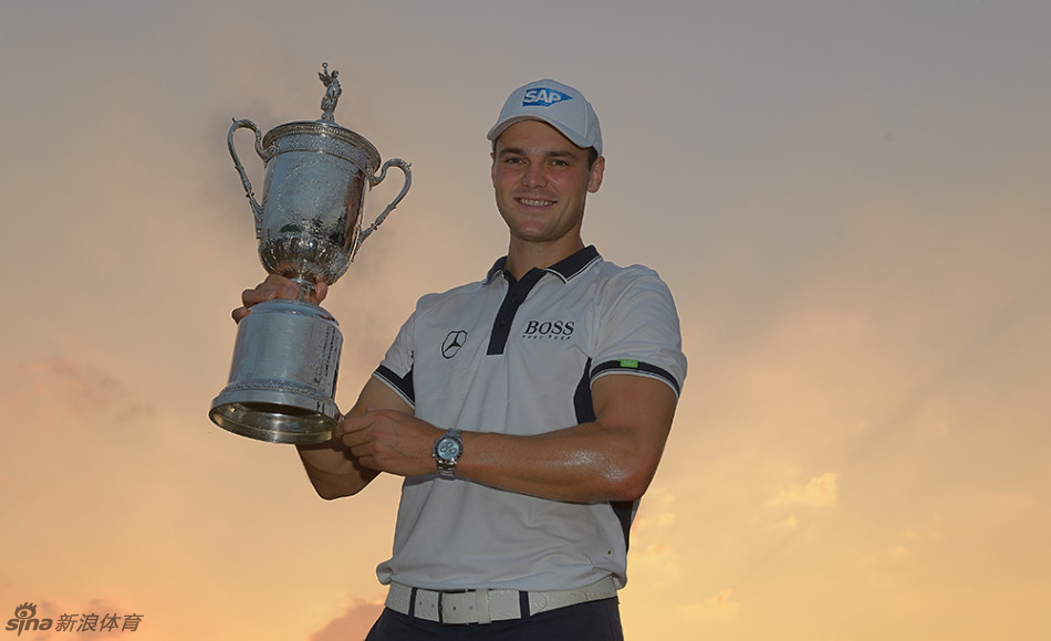 中国高尔夫名将梁文冲在练习果岭边，亲切地与一位手持推杆的小球迷合影留念。