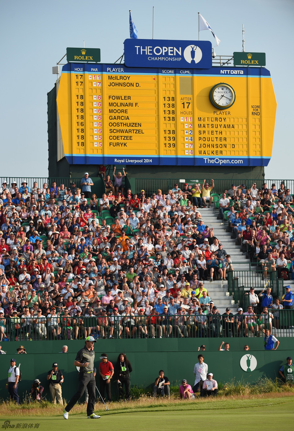 麦克罗伊在果岭上俯身仔细观察推杆线路，表情专注而沉稳，帽檐下眼神锐利，正在为关键一推做最后准备。