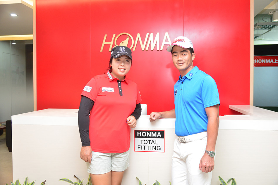 梁文冲在推杆果岭上亲自示范，向围绕他的小球迷们讲解推杆技巧