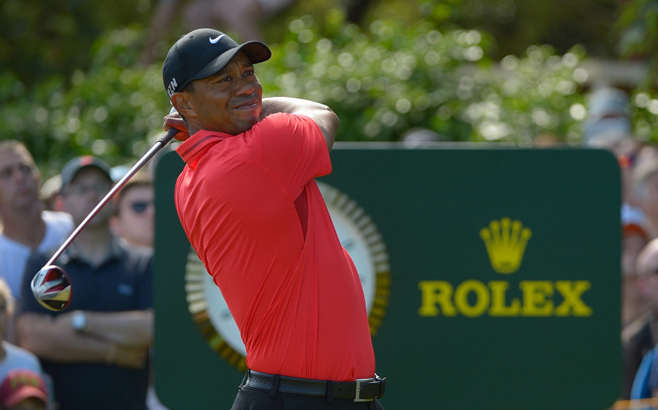 传奇球星泰格·伍兹在标志性的劳力士时钟前沉稳开球，凝聚力量与精准的一瞬，诠释了高尔夫运动的极致追求