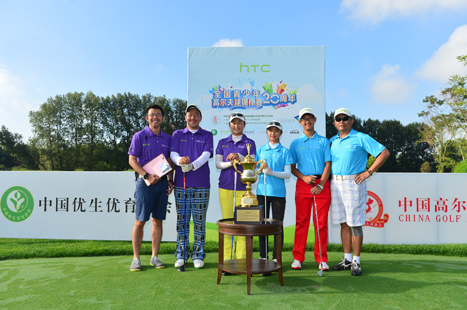 温馨鼓励：领队侧身与年轻队员深入交流，手指向球场方向，脸上带着信任的微笑，传递经验与力量。