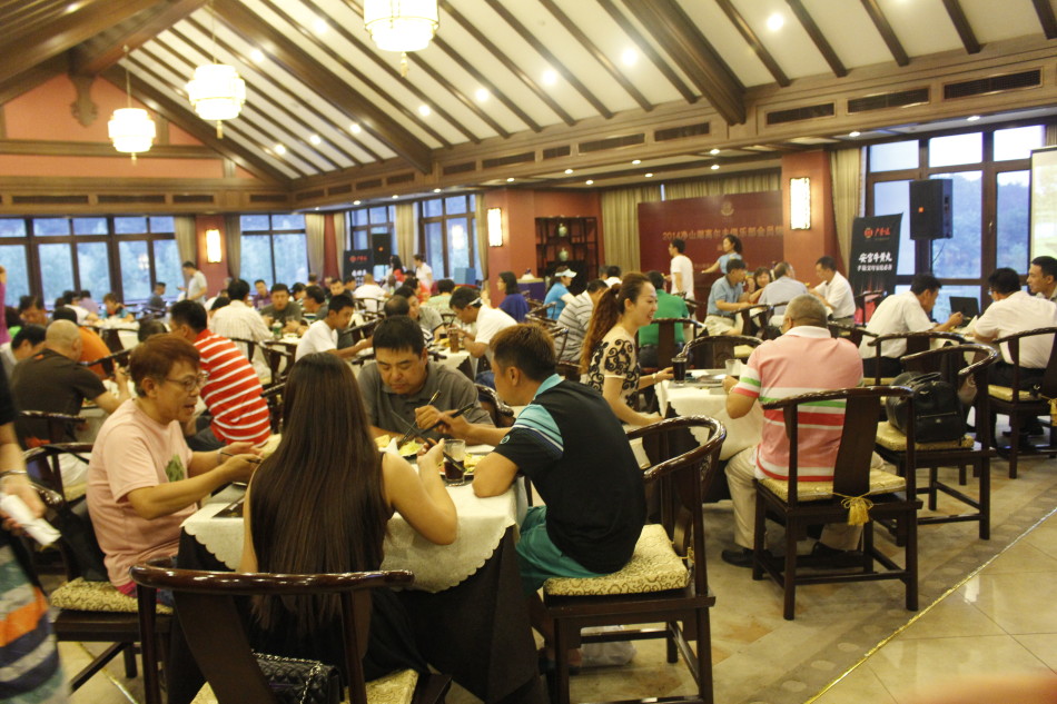 赛事颁奖典礼现场，获奖者们齐聚舞台手持奖杯合影，背景横幅彰显北京净山湖高尔夫俱乐部的赛事主题