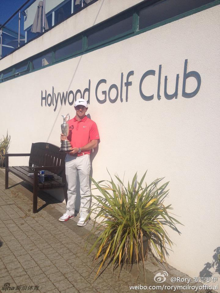 欢乐的团队围绕在麦克罗伊身边，他们高举酒杯，奖杯在人群中闪耀，庆祝的泡沫仿佛要溢出画面