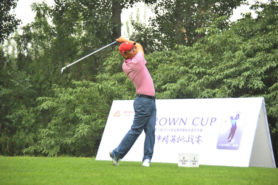 高尔夫选手弯腰凝视果岭，手指轻触草皮感受坡度，专注分析推杆路线，身旁的球童静静等待。