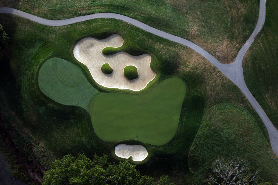 球员深陷沙坑困境,他眉头紧锁计算着击球路线,沙粒在阳光下闪烁如金色陷阱。