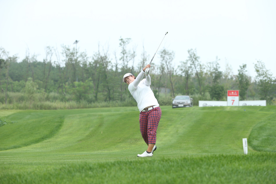 夕阳下球员走向下一个球洞，背影与球袋构成诗意图景，天空染成橙红色