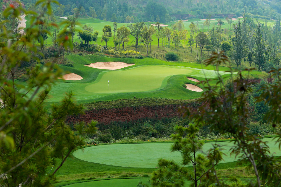 晨曦中的第一洞发球台，球道如绿毯铺展至远山脚下