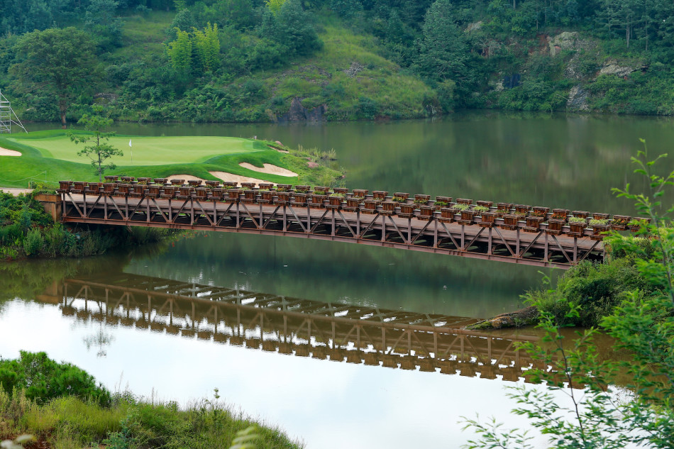 碧蓝湖泊守护着果岭，沙坑如月牙环抱，挑战与美景并存