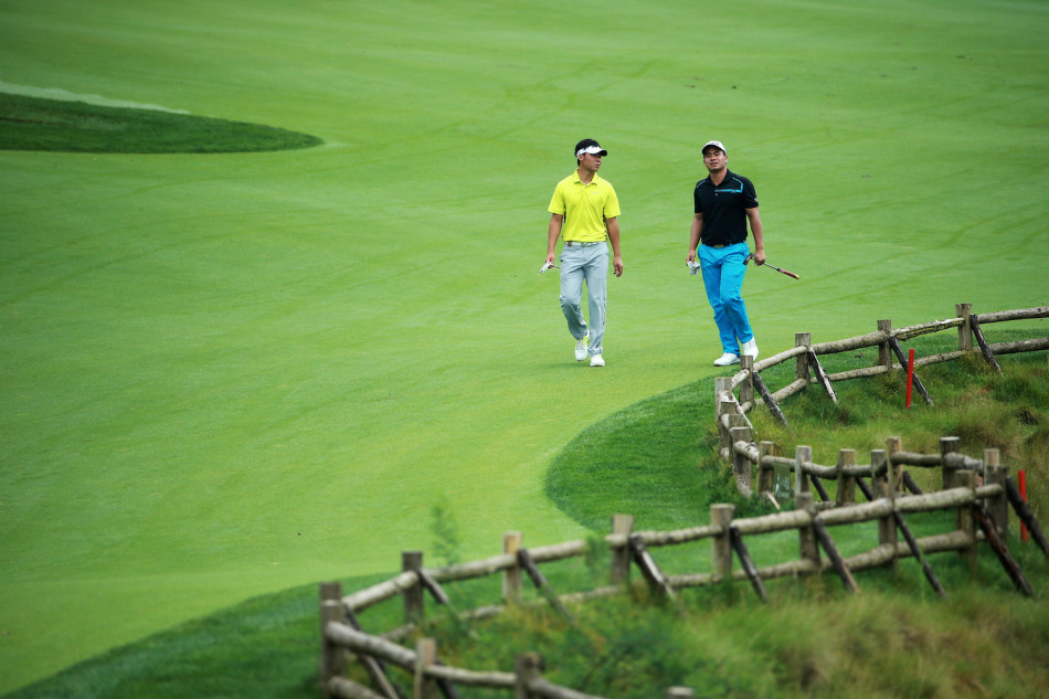 球员张一根在赛场上小憩，与球童交流，为接下来的比赛养精蓄锐，氛围轻松。