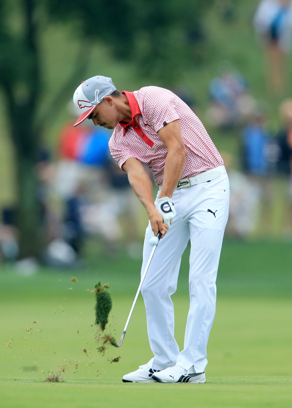 里奇·福勒的球杆刮起一片翠绿的草皮，瞬间的爆发力被凝固，泥土与草屑在空中飞溅，彰显击球动作的干净利落与力量感。