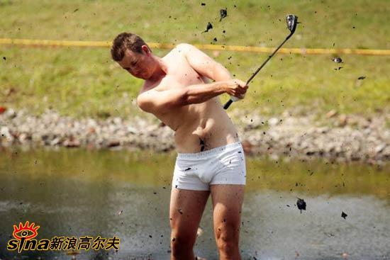 斯滕森的球童正单膝跪地，用毛巾仔细地擦拭着斯滕森沾满泥浆的小腿，主仆二人专注的神情中透露出默契与信任。