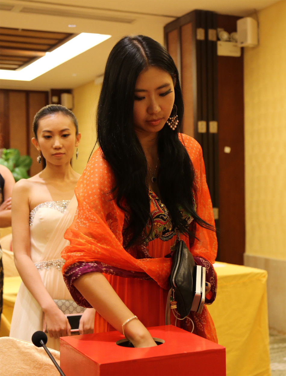 宣传介绍环节，佳丽们端坐台下认真聆听，眼神中充满求知的光芒，背景的大屏幕映出绚丽的画面，与她们的身影交相辉映。