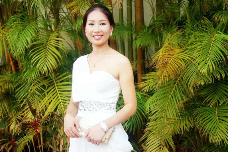 邱婷婷身着白色修身礼服倚靠跑车，回眸浅笑间尽显温婉气质，飘逸裙摆与流畅车身线条相映成趣