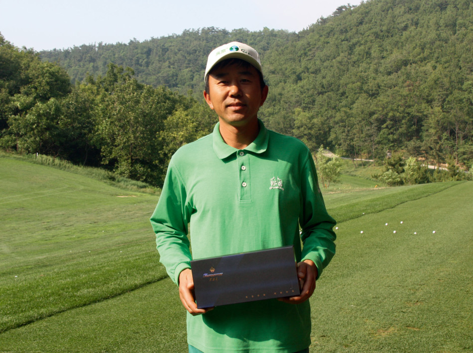 阳光洒在宁静的球道上，远处的水障碍与沙坑勾勒出充满挑战的完美弧线