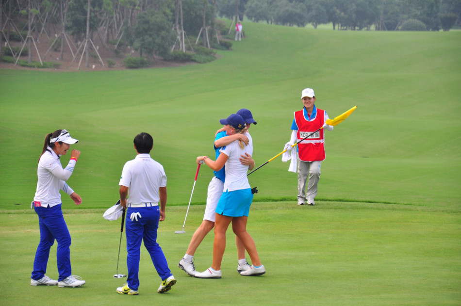 暮色中的关键一击：一位高尔夫球手在全神贯注地推杆，球洞近在咫尺，背景的观众屏息凝神，赛场氛围紧张而凝练。