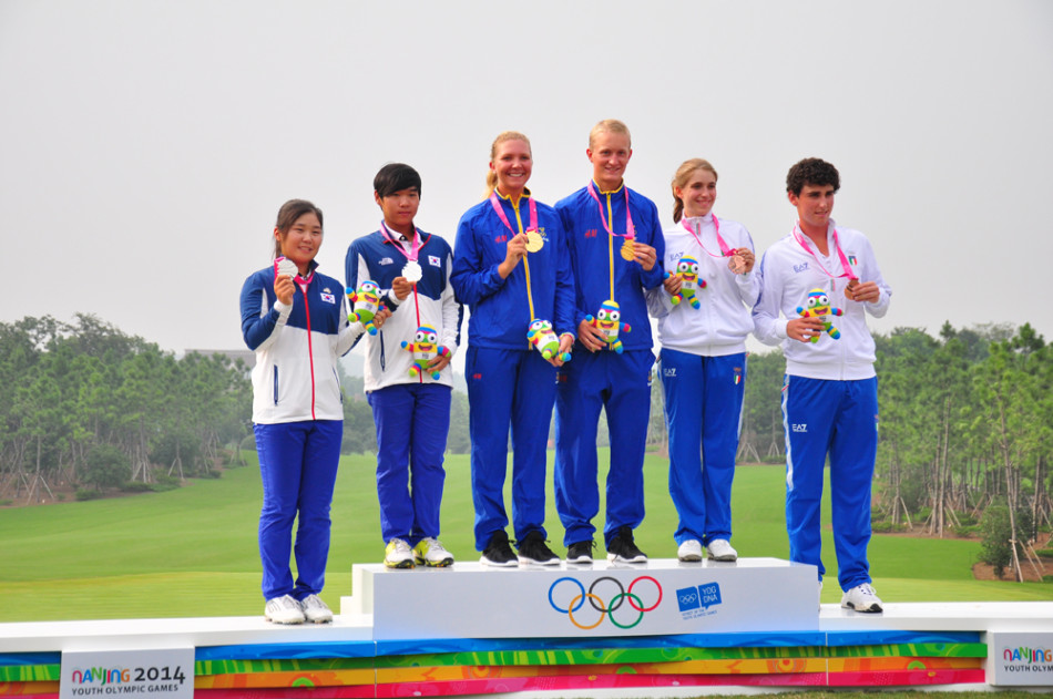 列队欢迎的温暖笑容：志愿者们身着统一服装，排成整齐的队列，面带热情洋溢的笑容，鼓掌欢迎前来参与活动的巴赫先生一行。